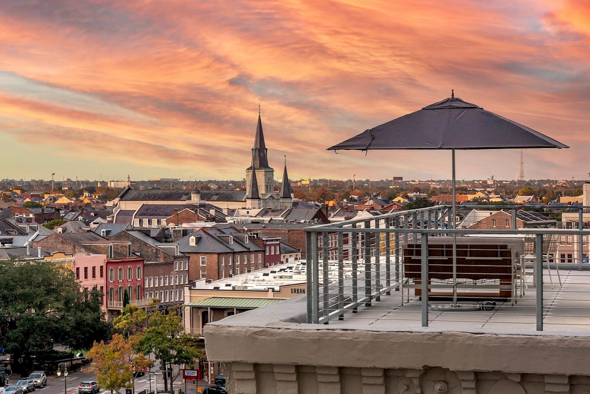 A rooftop patio with a view of the city at sunset